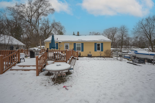 snow covered property with a deck