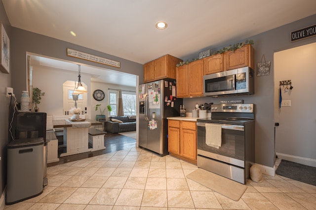 kitchen with pendant lighting, stainless steel appliances, and light tile patterned flooring