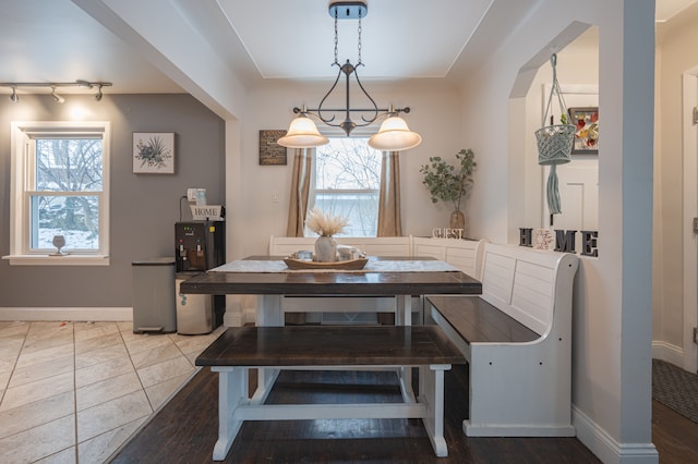 dining area with track lighting and tile patterned floors