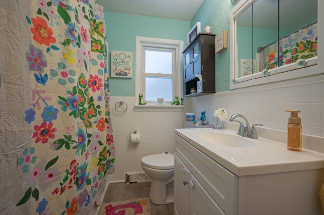 bathroom with tile walls, toilet, vanity, and a shower with shower curtain