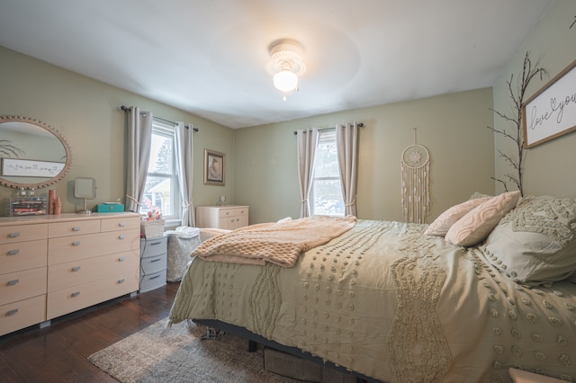 bedroom with dark wood-type flooring and multiple windows