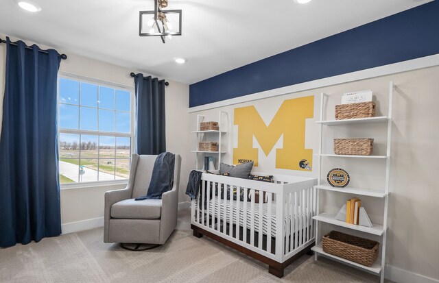 carpeted bedroom featuring a notable chandelier and a crib