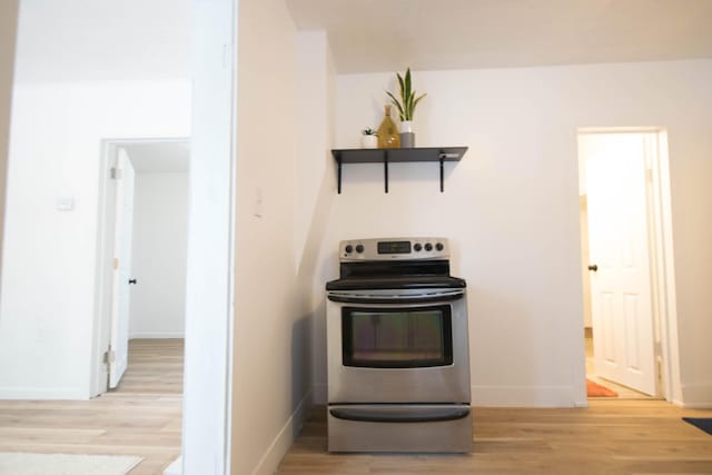 kitchen with stainless steel electric range oven and light wood-type flooring