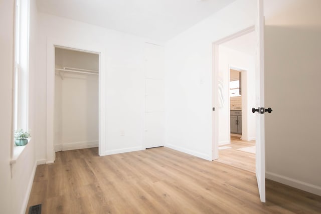 unfurnished bedroom featuring a closet and light hardwood / wood-style flooring