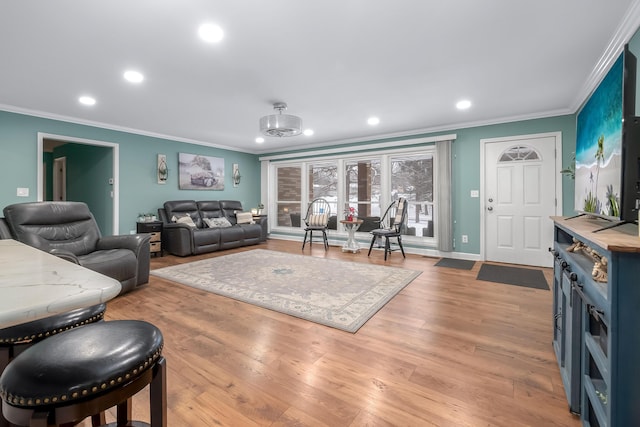 living room featuring an inviting chandelier, crown molding, and light hardwood / wood-style floors