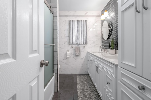 bathroom featuring vanity, tile walls, and shower / bath combination with glass door