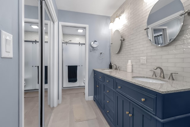 bathroom featuring decorative backsplash, toilet, vanity, and tile patterned flooring