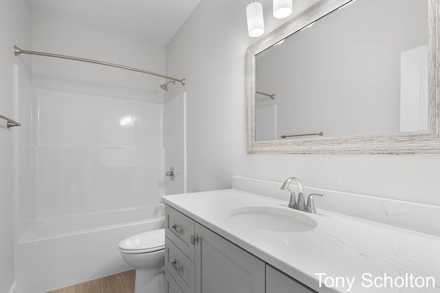 bathroom featuring vanity, bathing tub / shower combination, toilet, and wood finished floors