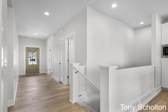 hall featuring recessed lighting, baseboards, an upstairs landing, and wood finished floors