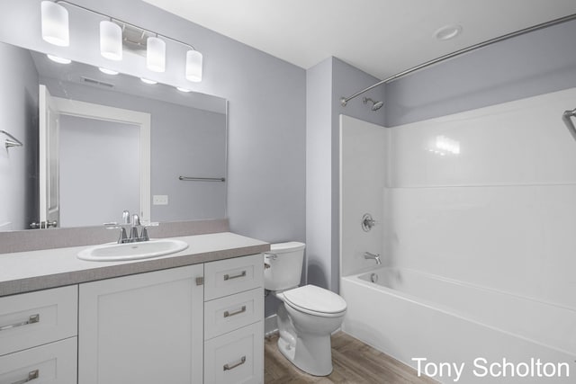 full bathroom with visible vents, wood finished floors, shower / washtub combination, vanity, and toilet