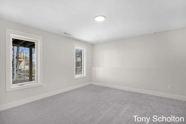 spare room with baseboards, visible vents, and a wealth of natural light