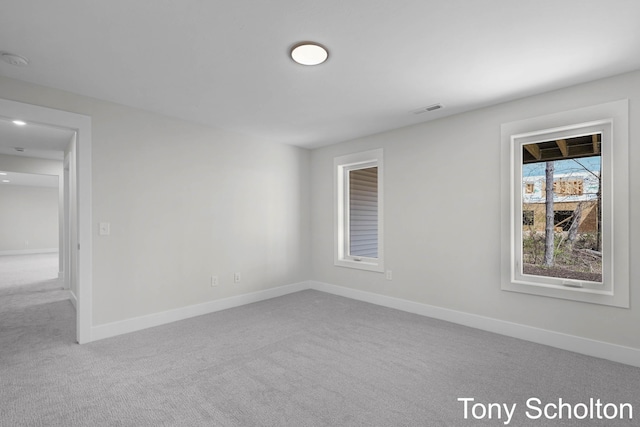carpeted spare room with baseboards and visible vents