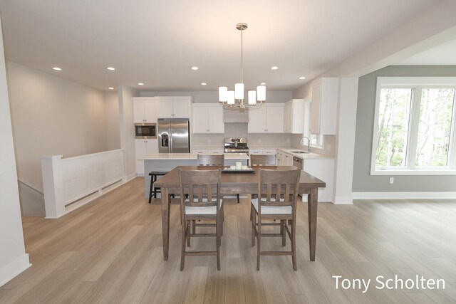 5157 Blendon Wds Ct Unit 15, Hudsonville, MI 49426 - dining room with light wood finished floors, a chandelier, baseboards, and recessed lighting