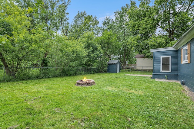 view of yard with an outdoor fire pit and a storage unit