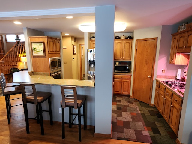 kitchen featuring a breakfast bar, kitchen peninsula, and stainless steel appliances