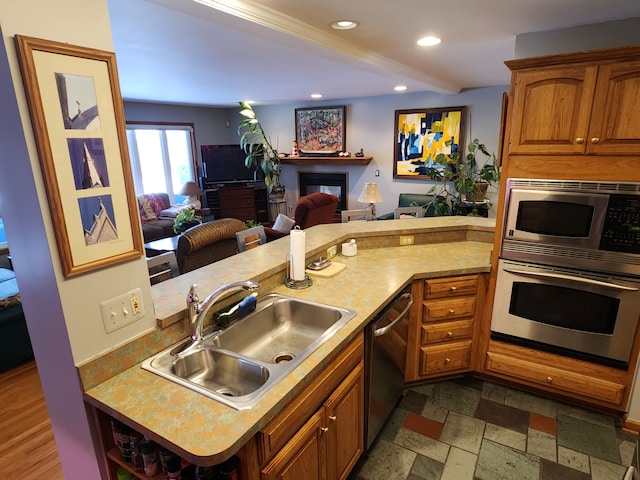 kitchen with appliances with stainless steel finishes, kitchen peninsula, and sink