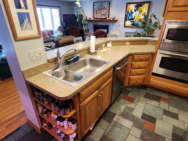 kitchen featuring sink, kitchen peninsula, and stainless steel appliances