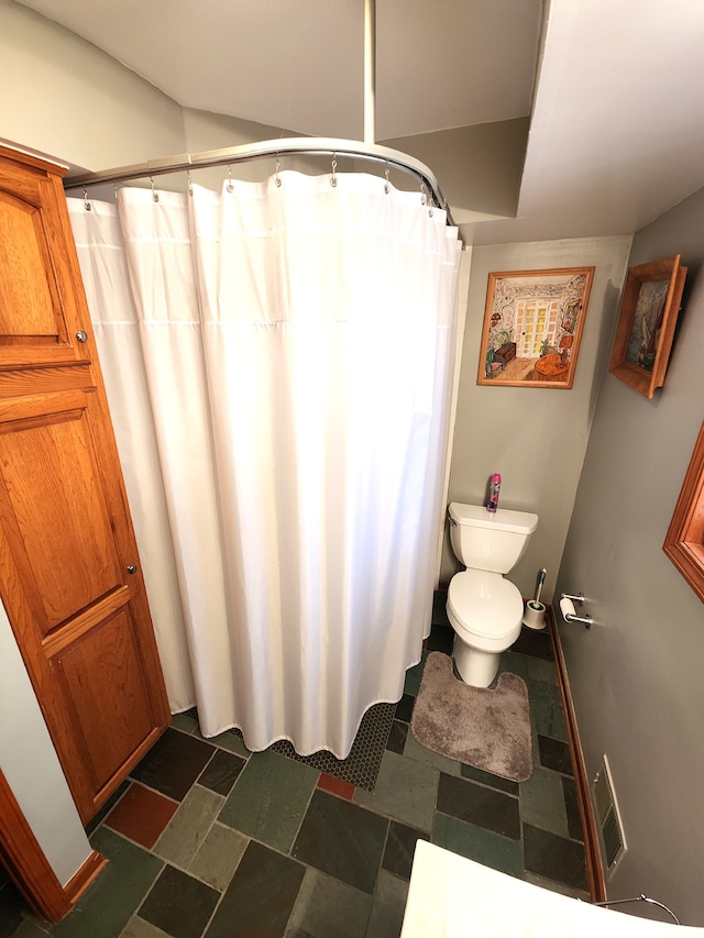 bathroom with toilet and a shower with curtain