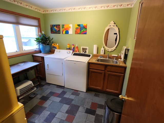 laundry room with cabinets, washer and dryer, and sink