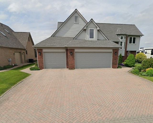 view of front of property featuring central AC and a garage