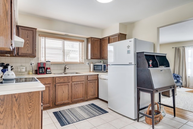 kitchen with white appliances, sink, backsplash, ventilation hood, and light tile patterned flooring