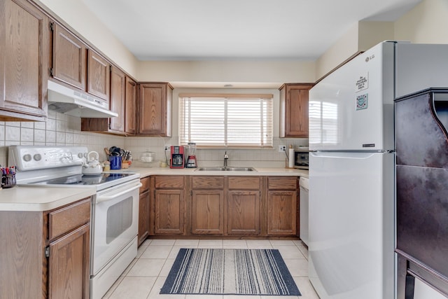 kitchen with light tile patterned floors, sink, backsplash, and white appliances