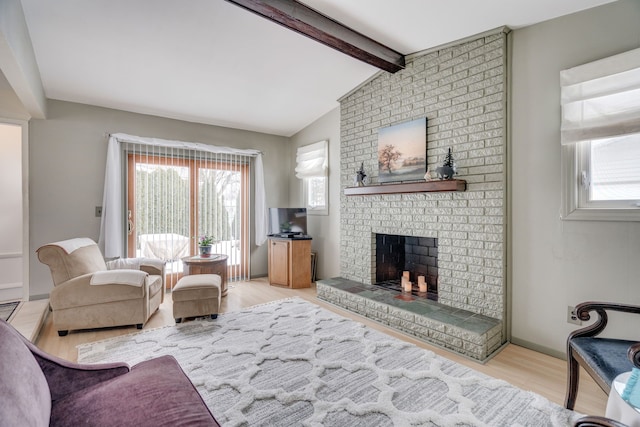 living room featuring a fireplace, light hardwood / wood-style floors, and lofted ceiling with beams