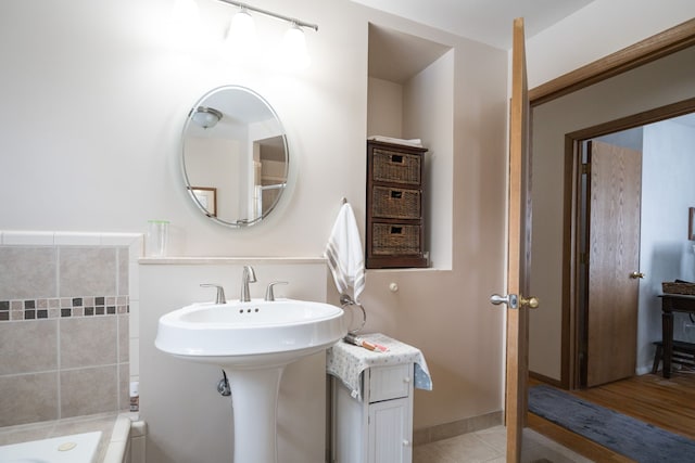 bathroom with tile patterned flooring and a tub