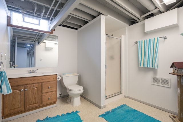 bathroom featuring toilet, a shower with shower door, and vanity