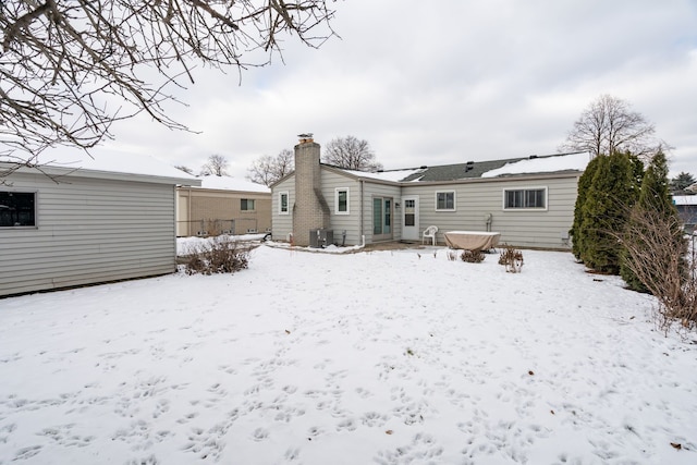 snow covered property with central AC