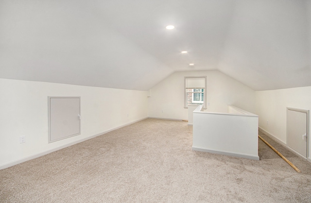 additional living space with light carpet and vaulted ceiling