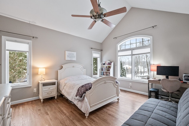 bedroom with ceiling fan, multiple windows, light hardwood / wood-style flooring, and lofted ceiling