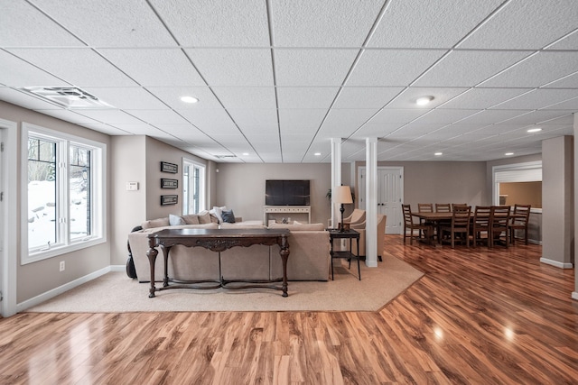 living room featuring a drop ceiling and hardwood / wood-style flooring