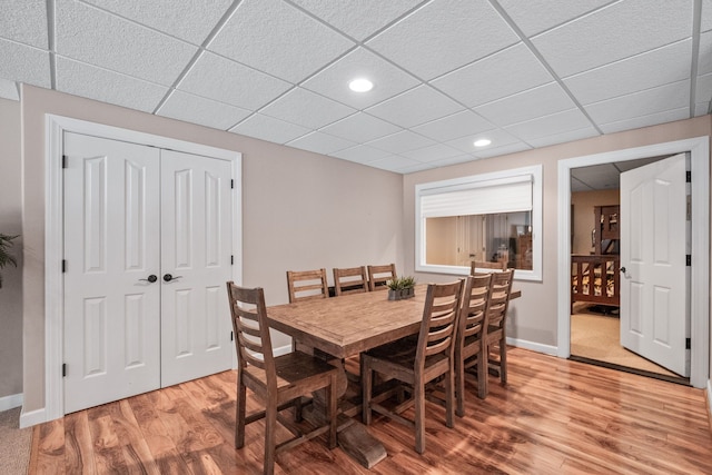 dining space featuring a paneled ceiling and hardwood / wood-style flooring