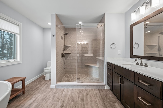 bathroom with toilet, hardwood / wood-style flooring, an enclosed shower, and vanity