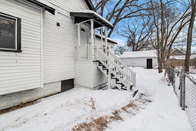 snow covered property with an outbuilding