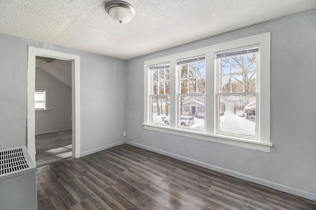 unfurnished dining area featuring a textured ceiling and dark hardwood / wood-style floors