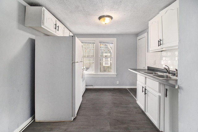 kitchen with sink, backsplash, white cabinets, and white fridge