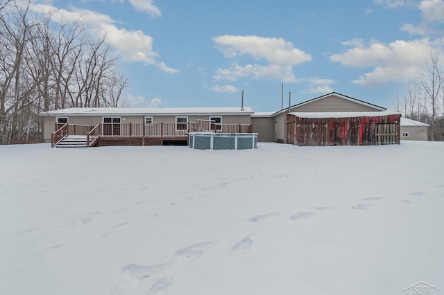 snow covered back of property with a swimming pool side deck