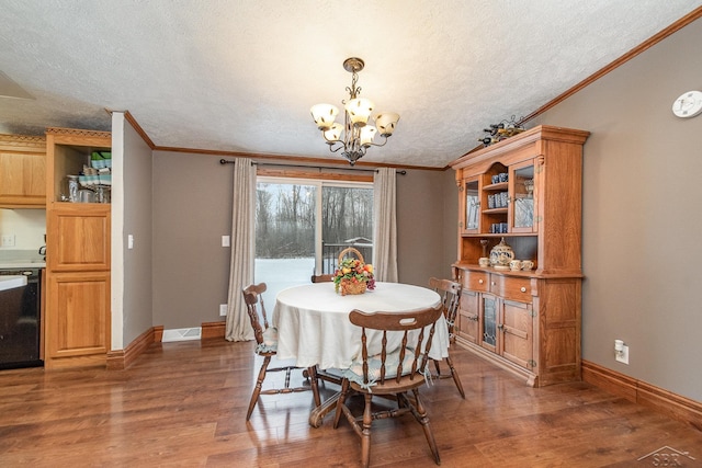 dining space featuring a textured ceiling, ornamental molding, dark hardwood / wood-style floors, and a notable chandelier