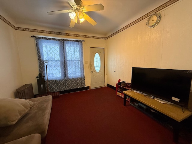 interior space with ceiling fan, carpet, and radiator heating unit