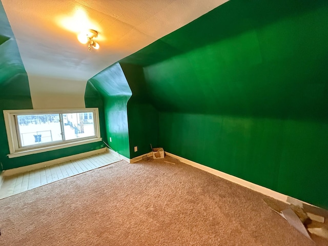 bonus room featuring vaulted ceiling and carpet flooring