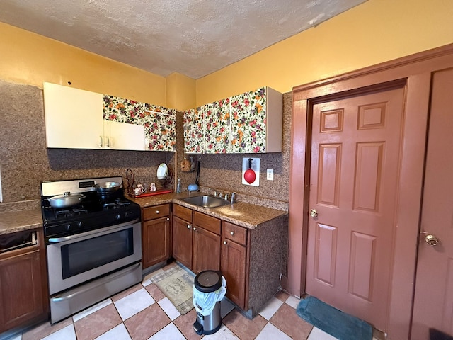 kitchen featuring sink, backsplash, stainless steel range with gas stovetop, and a textured ceiling