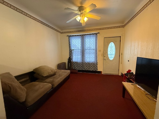 carpeted living room featuring ceiling fan and radiator heating unit