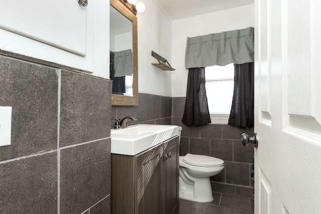 bathroom with tile patterned floors, tile walls, toilet, and vanity