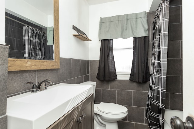 bathroom with toilet, vanity, tile walls, and a shower with shower curtain