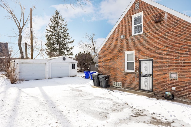 view of snowy exterior with a garage and an outdoor structure