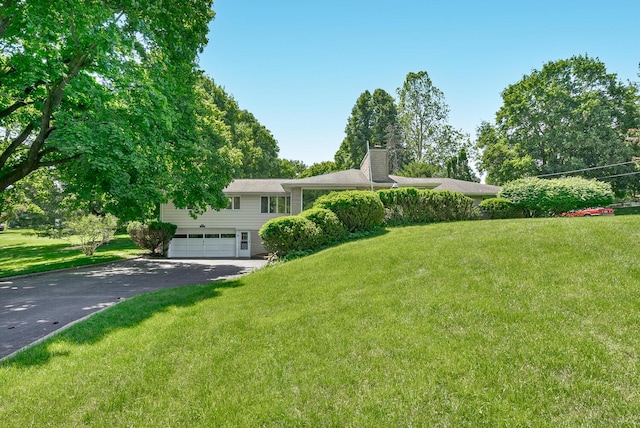 view of front of property with a garage and a front lawn