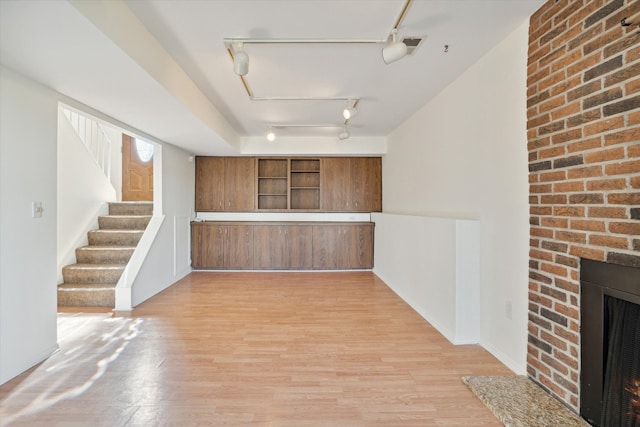 kitchen with rail lighting, wood-type flooring, and a fireplace