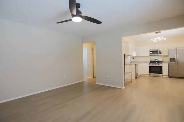 unfurnished living room featuring ceiling fan, sink, and light hardwood / wood-style flooring